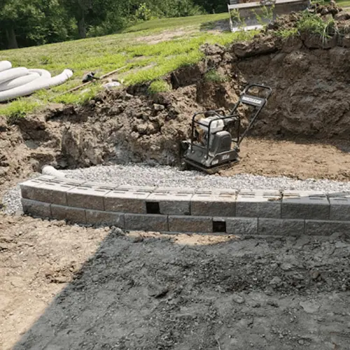 compactor next to beginning of retaining wall