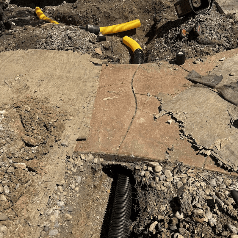 downspout drain under patio walkway