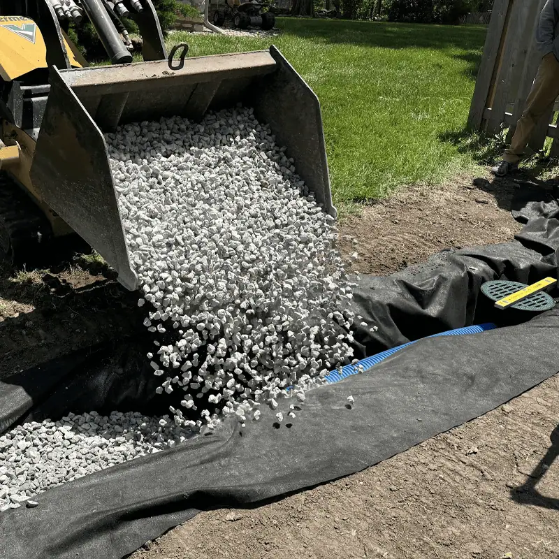 gravel being poured into french drain