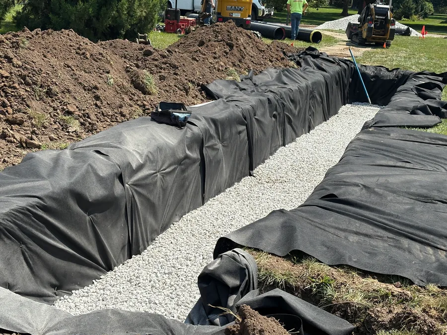 Washed gravel backfilled around the fabric-wrapped chambers along the length of the leach bed